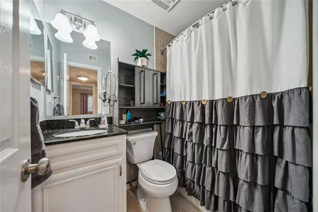 a bathroom with a toilet a sink and mirror