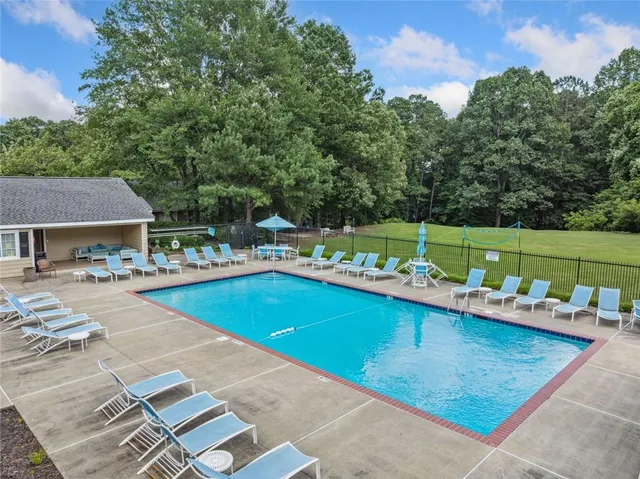 a view of a swimming pool with a lounge chairs and a yard