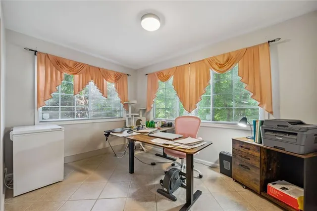 a work room with furniture and large windows
