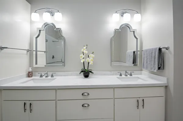 a bathroom with double vanity sinks and a mirror