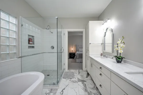 a spacious bathroom with a granite countertop sink mirror and bathtub