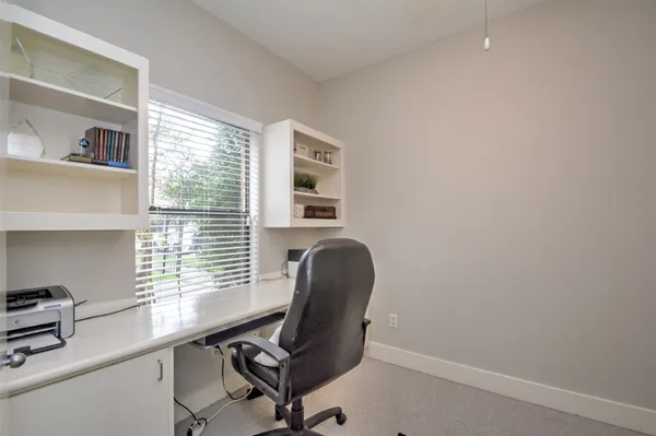 a view of a workspace with furniture and a window