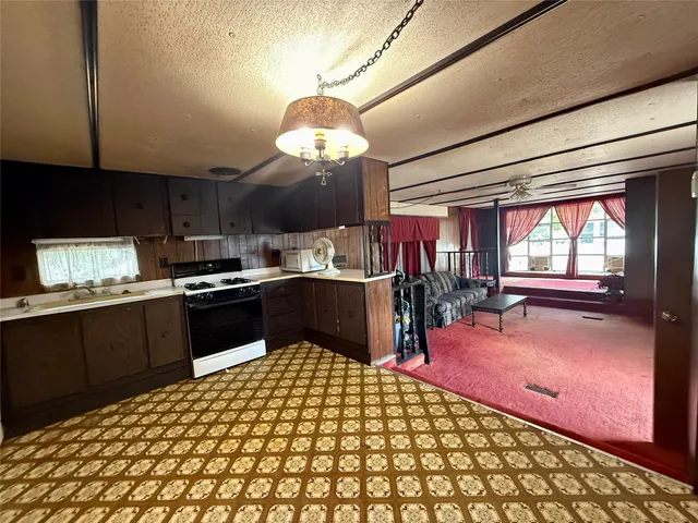 a kitchen with stainless steel appliances kitchen island granite countertop a refrigerator and a stove top oven