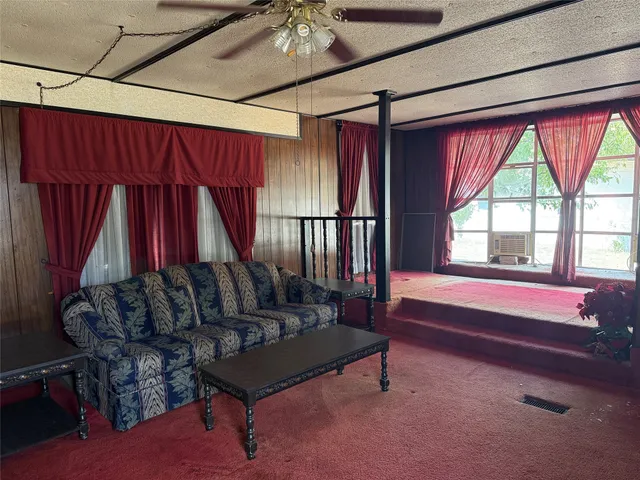 a living room with furniture a bed and a large window