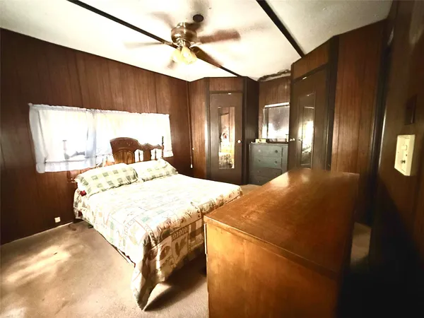 a bedroom with a bed mirror and window