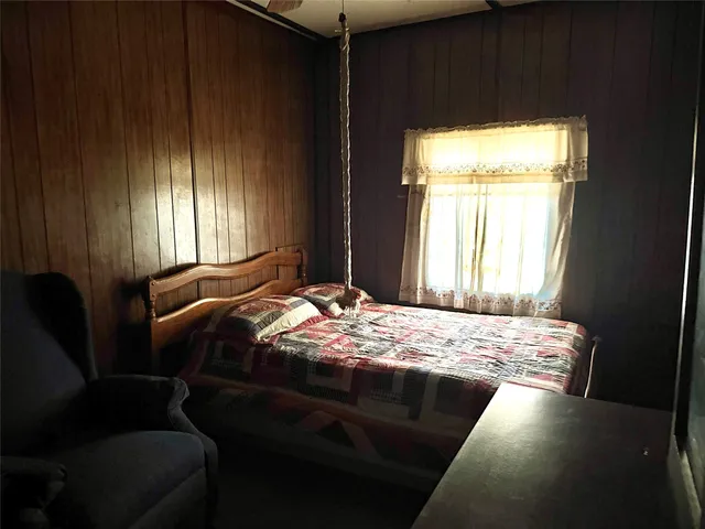a bedroom with a bed next to a window
