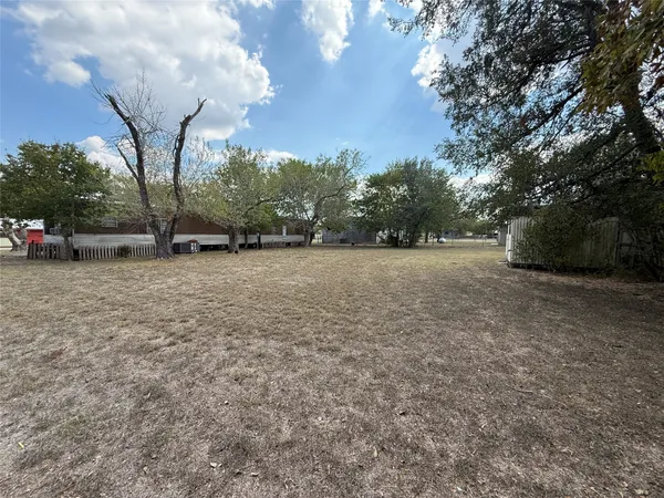 a view of a field with trees in the background