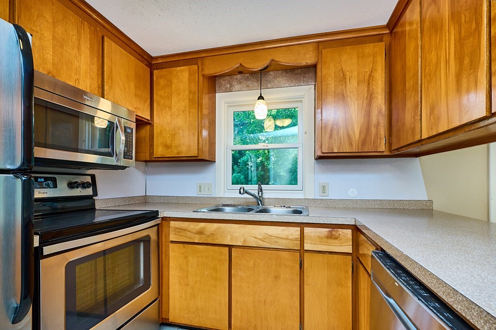 134 Tracy Circle Amherst, MA 01002 - Photo 7 of 37 a kitchen with stainless steel appliances a stove a sink and a microwave