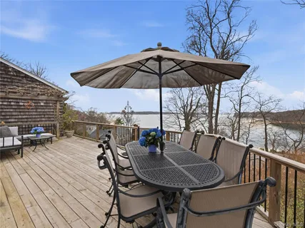 a view of deck with table and chairs under an umbrella with wooden floor