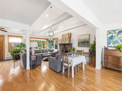 a living room with furniture dining table wooden floor and a large window