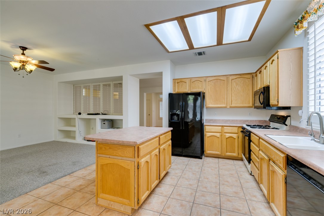 2189 Chapman Ranch Drive Henderson, NV 89012 - Photo 27 of 60 Ample wooden cabinetry and tile flooring define this functional kitchen layout.