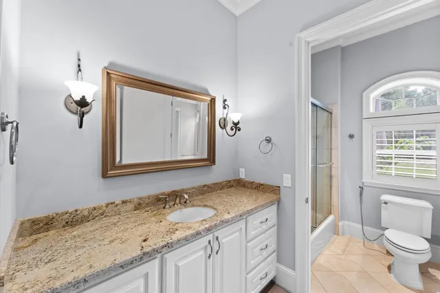 a bathroom with a granite countertop sink a mirror and a shower