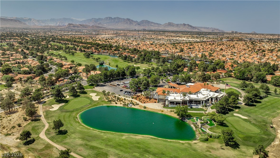 7995 Rio Rico Drive Las Vegas, NV 89113 - Photo 81 of 92 An aerial panorama reveals a vast golf course community with a sparkling lake, lush greens, and an inviting clubhouse.