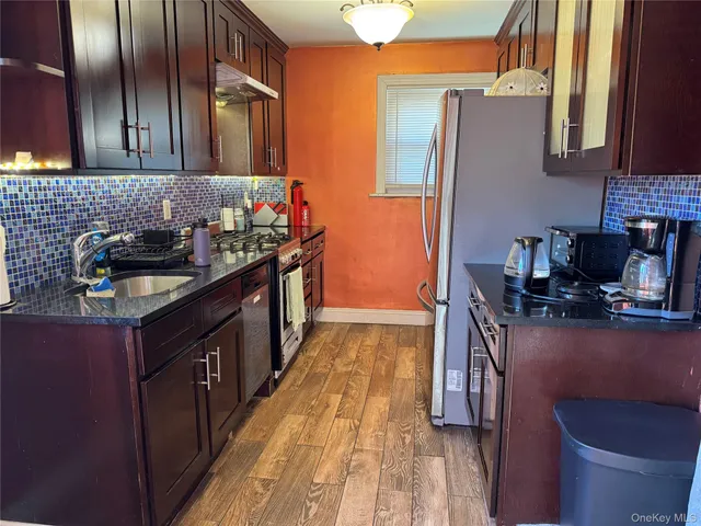a kitchen with granite countertop a sink stove and cabinets