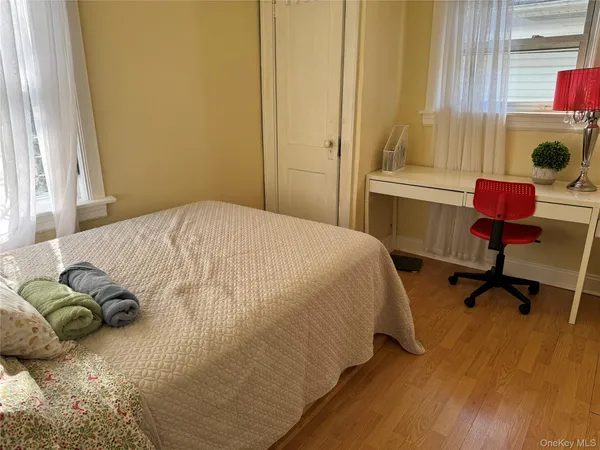 a bedroom with a bed and a dresser next to a window