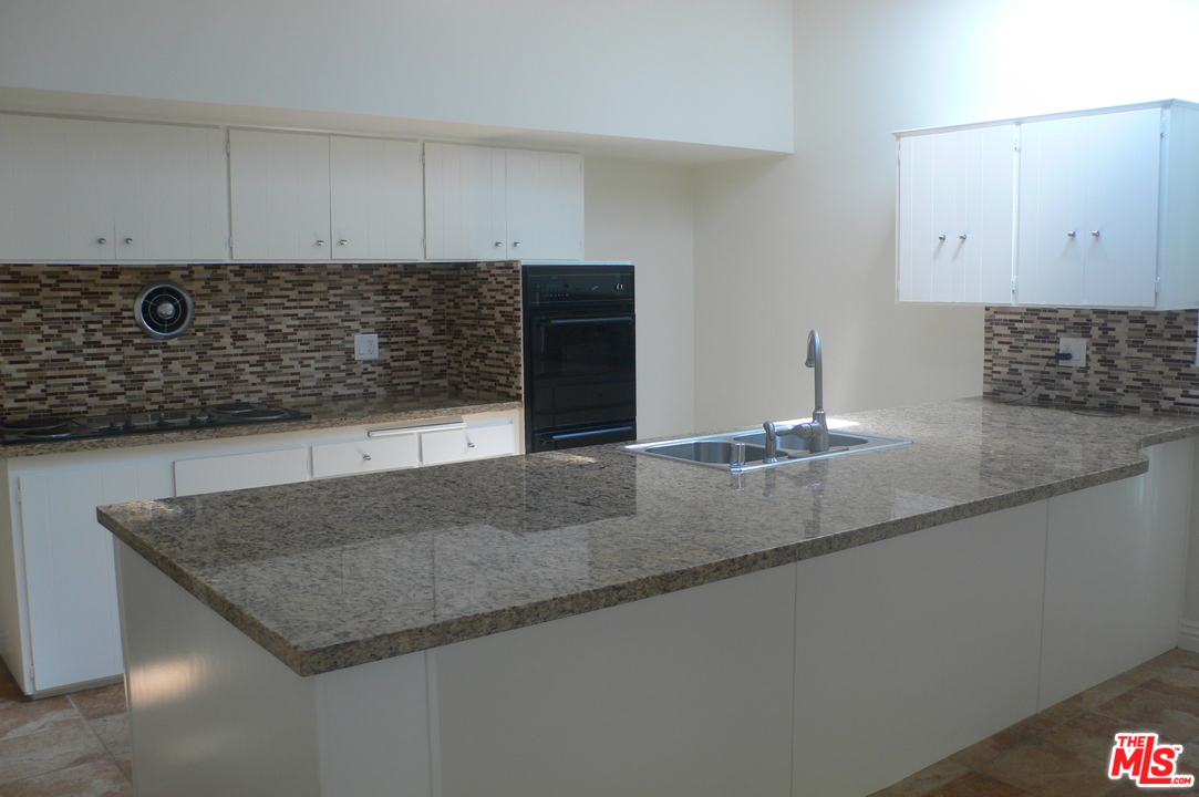 2101 Roscomare Road Los Angeles, CA 90077 - Photo 3 of 8 a kitchen with granite countertop a sink and a stove