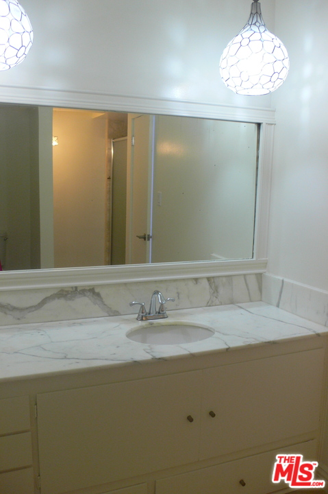 2101 Roscomare Road Los Angeles, CA 90077 - Photo 7 of 8 a bathroom with a sink and a mirror