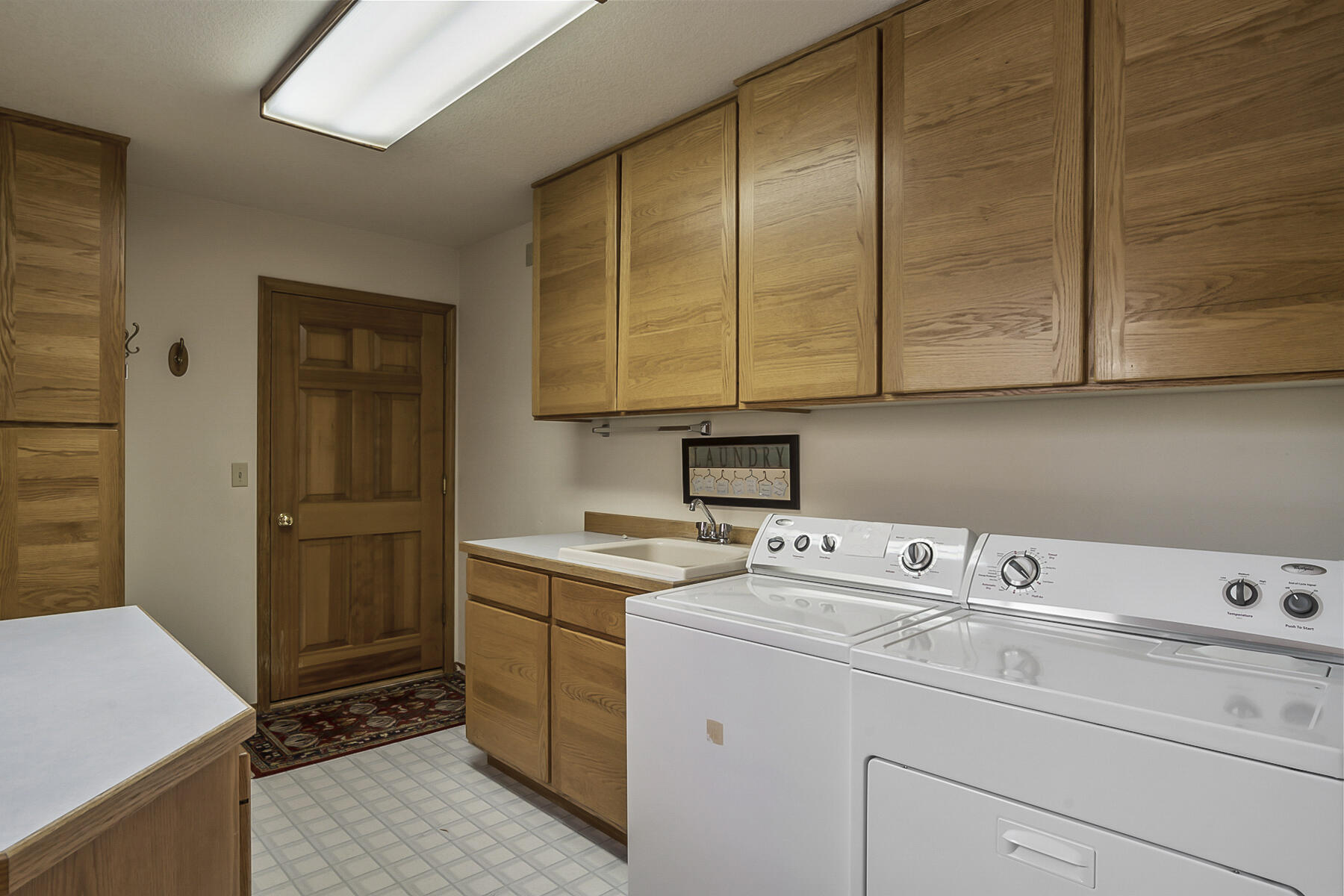 3808 Northwest Summerfield Road Bend, OR 97703 - Photo 24 of 38 Massive laundry room with utility sink, more than enough cupboard space and folding counter. Secret laundry shoot from upstairs conveniently empties directly above washer and dryer.