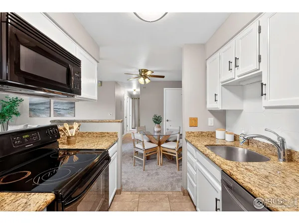 a kitchen with granite countertop a stove sink and microwave