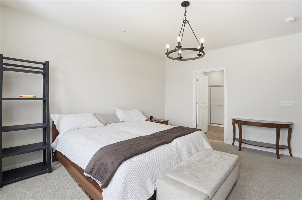 2306 Talbot Way, Unit 2306 Westborough, MA 01581 - Photo 13 of 37 a bedroom with a bed and a dresser with rug