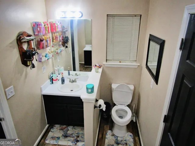 a bathroom with a sink vanity mirror and toilet