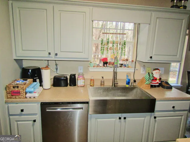 a kitchen with a sink a stove and cabinets