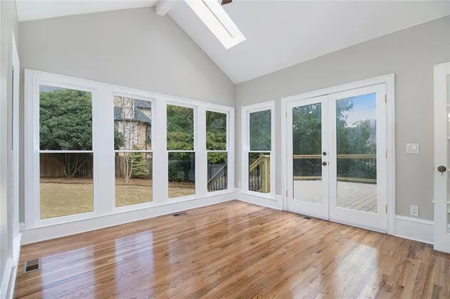a view of empty room with wooden floor and fireplace