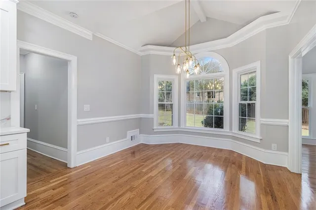 a large kitchen with granite countertop a stove top oven a sink a counter space and wooden floor