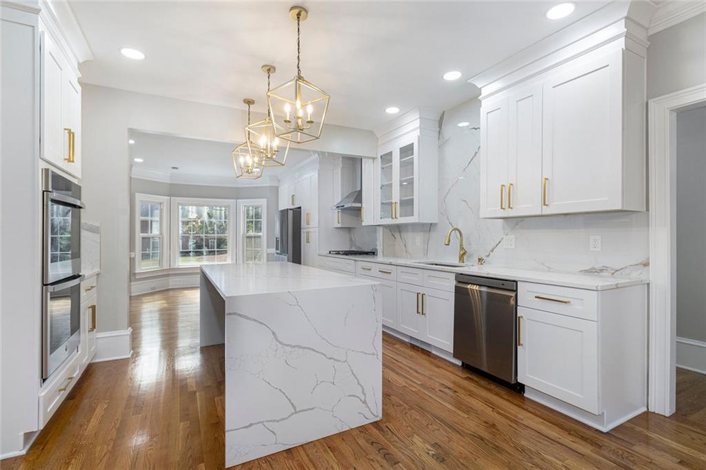 2820 Harwick Drive Atlanta, GA 30350 - Photo 16 of 48 a large kitchen with granite countertop a stove top oven a sink a counter space and wooden floor