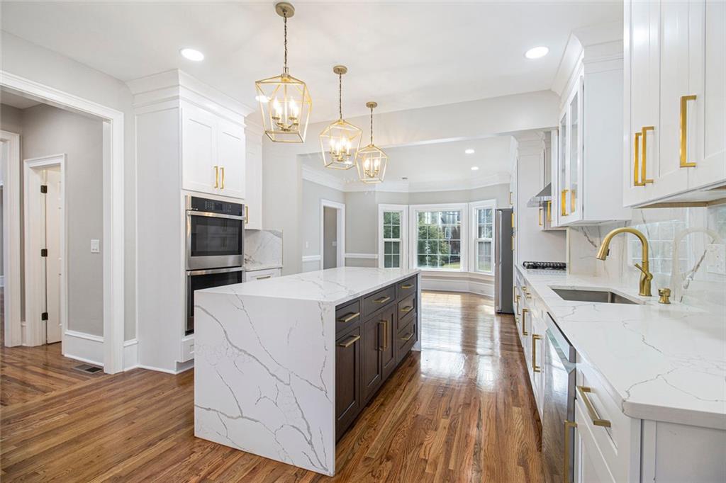 2820 Harwick Drive Atlanta, GA 30350 - Photo 17 of 48 a large kitchen with kitchen island a stove a sink a refrigerator wooden floor and cabinets