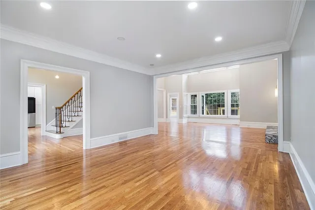 a view of an empty room with wooden floor and floor to ceiling window