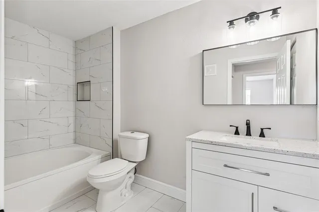 a bathroom with a toilet a sink a mirror a bathtub and shower