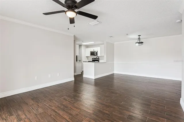 a view of a kitchen with wooden floor and a ceiling fan