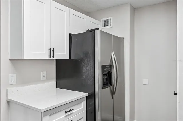 a kitchen with stainless steel appliances a refrigerator and cabinets