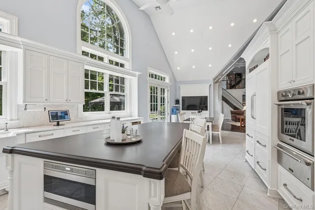 a kitchen with stainless steel appliances granite countertop a sink and a white cabinets
