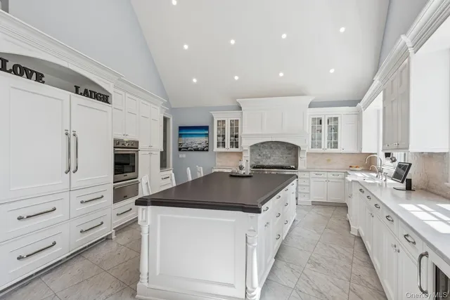 a kitchen with white cabinets and appliances
