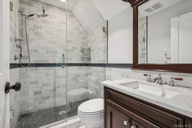 a bathroom with a sink a toilet and shower