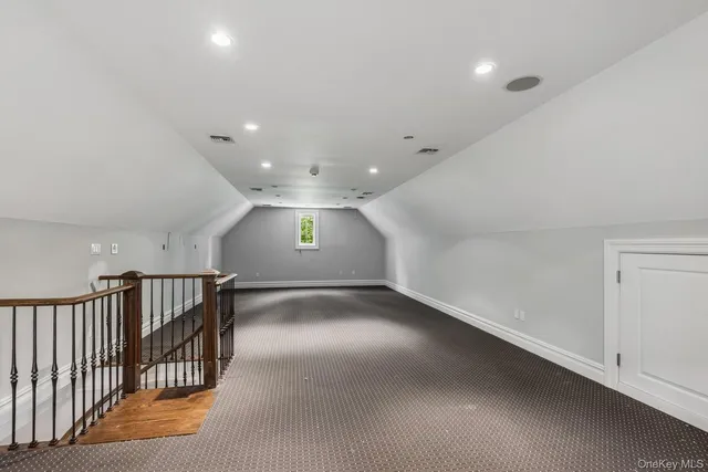 an empty room with stairs and windows