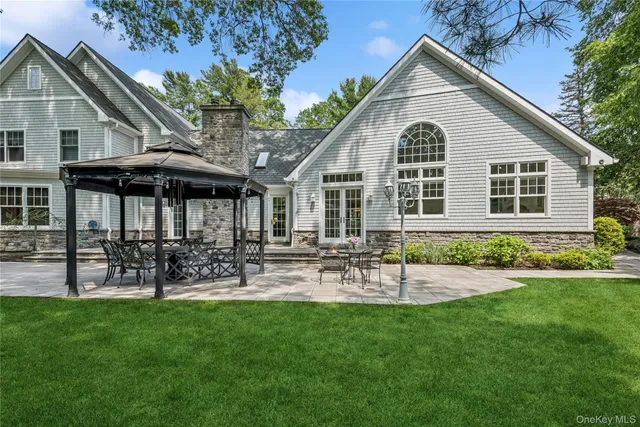 a view of a house with a yard and chairs