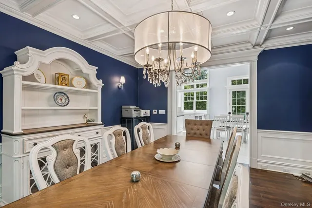 a view of a dining room with furniture a chandelier and wooden floor