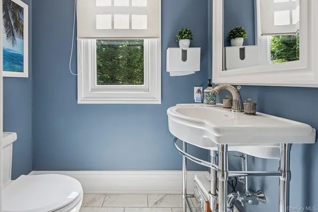 a bathroom with a sink a toilet and a window