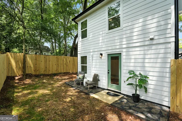 a view of backyard with wooden fence and a large tree