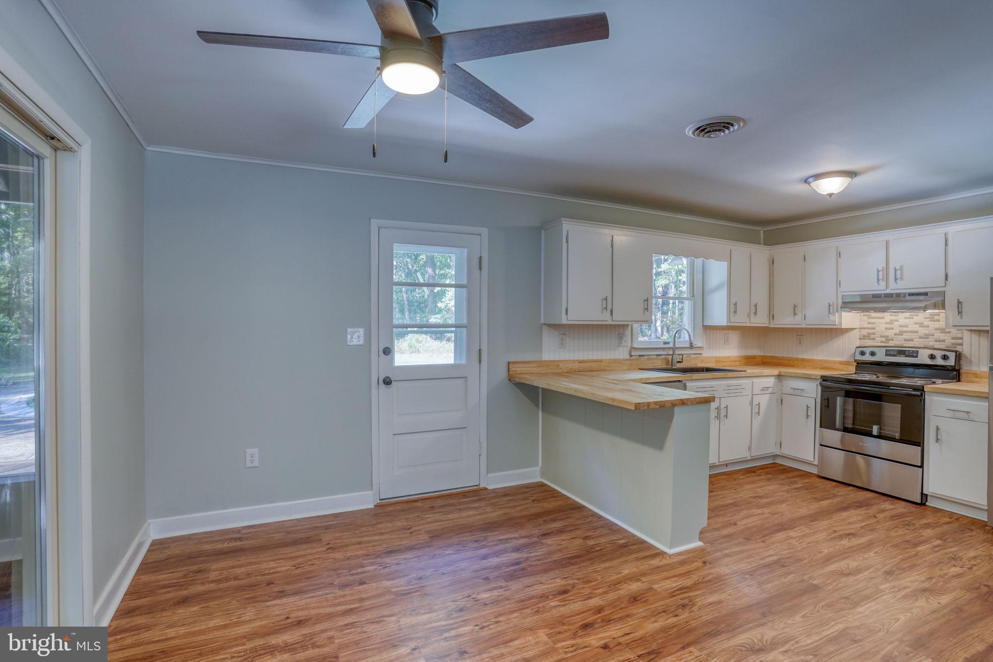 4570 Evergreen Road Oxford, MD 21654 - Photo 13 of 27 a kitchen with granite countertop a sink cabinets and wooden floor