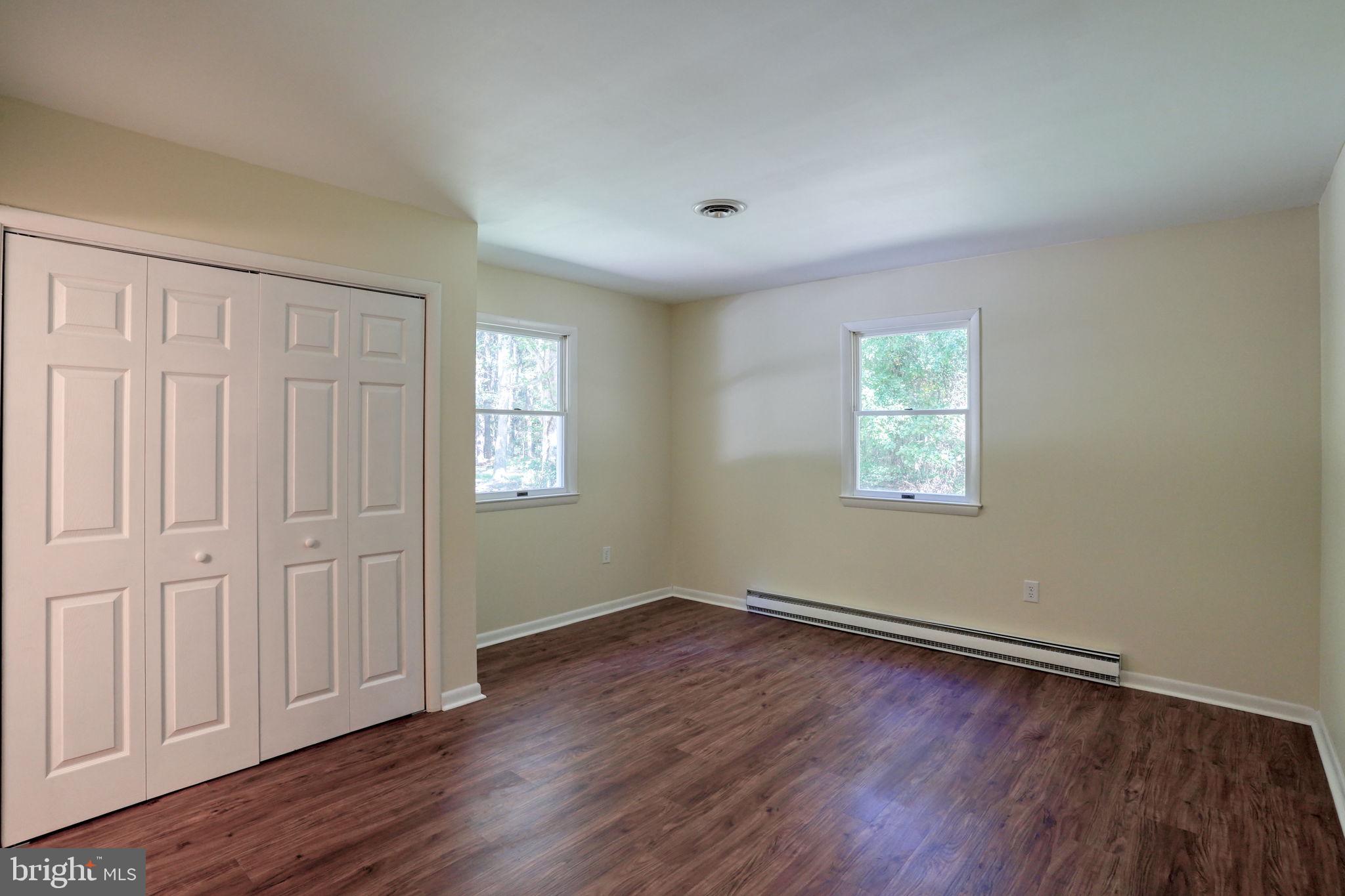 4570 Evergreen Road Oxford, MD 21654 - Photo 23 of 27 an empty room with wooden floor and windows