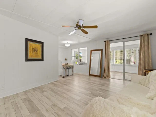 a view of a livingroom with wooden floor and a ceiling fan