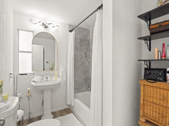 a bathroom with a sink a toilet and shower