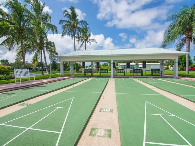 a view of a swimming pool with a lawn chairs next to a road