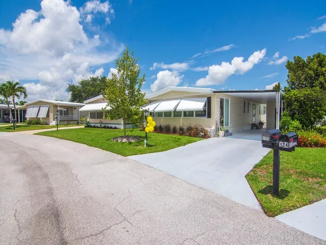 a view of a house with a yard and potted plants