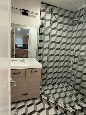 a bathroom with a sink mirror and shower