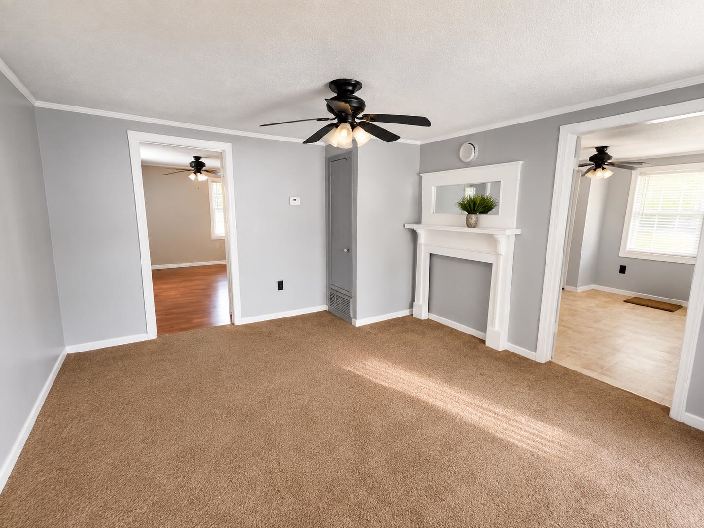 7503 Walsh Road Millington, TN 38053 - Photo 3 of 27 Neutral wall paint with contrasting white trim, ceiling fan with light kit, built-in wall unit, and decorative fireplace surround
